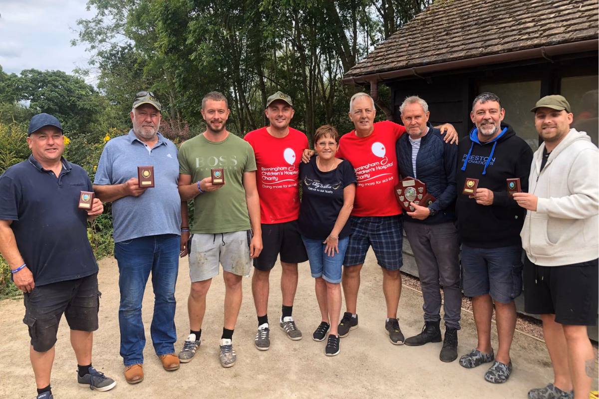 Simon Wilkes with friends and family holding awards for catch