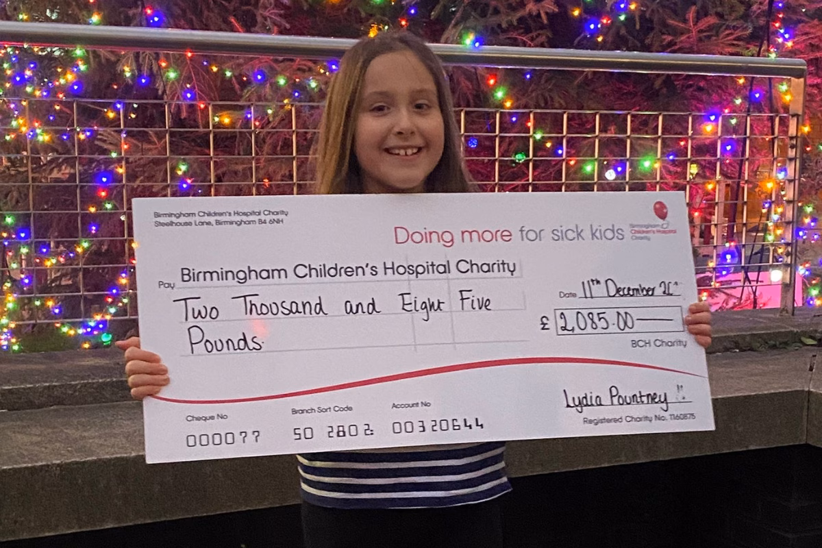 Brownie holding her giant fundraising cheque for the hospital charity