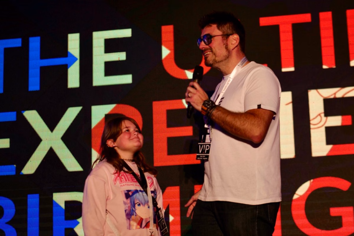 Dad on stage speaking with daughter