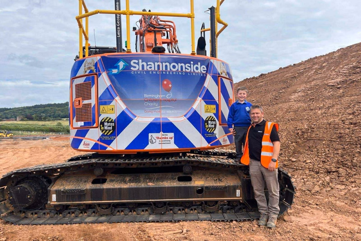 Jack with his dad in front of construction excavator
