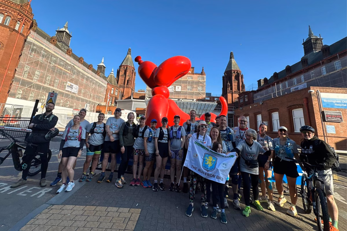Group of runners standing in front of balloon dog statue