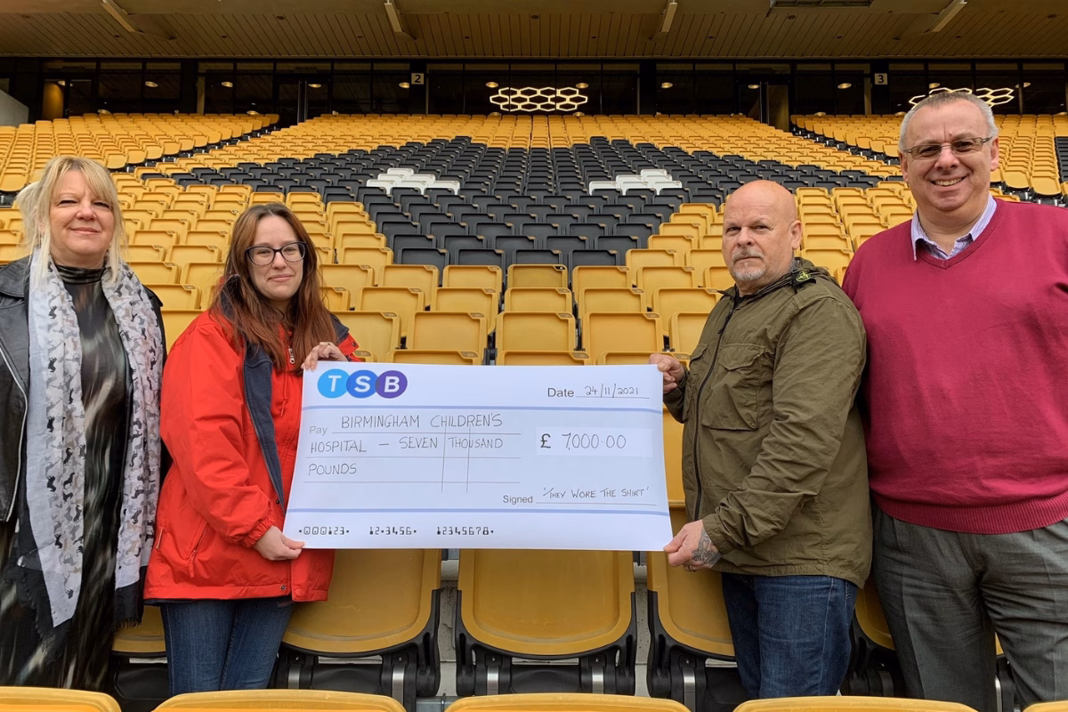 Steve Plant holding fundraising cheque to our hospital for £7,000 at Wolverhampton Wolves stadium