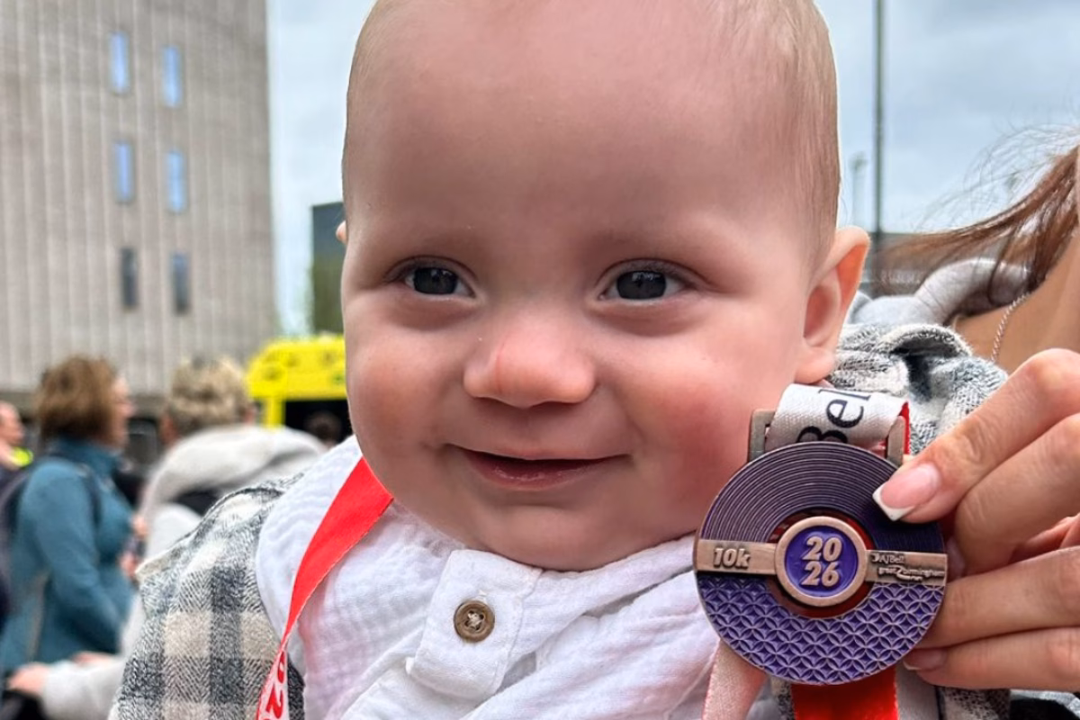 Baby holding running medal