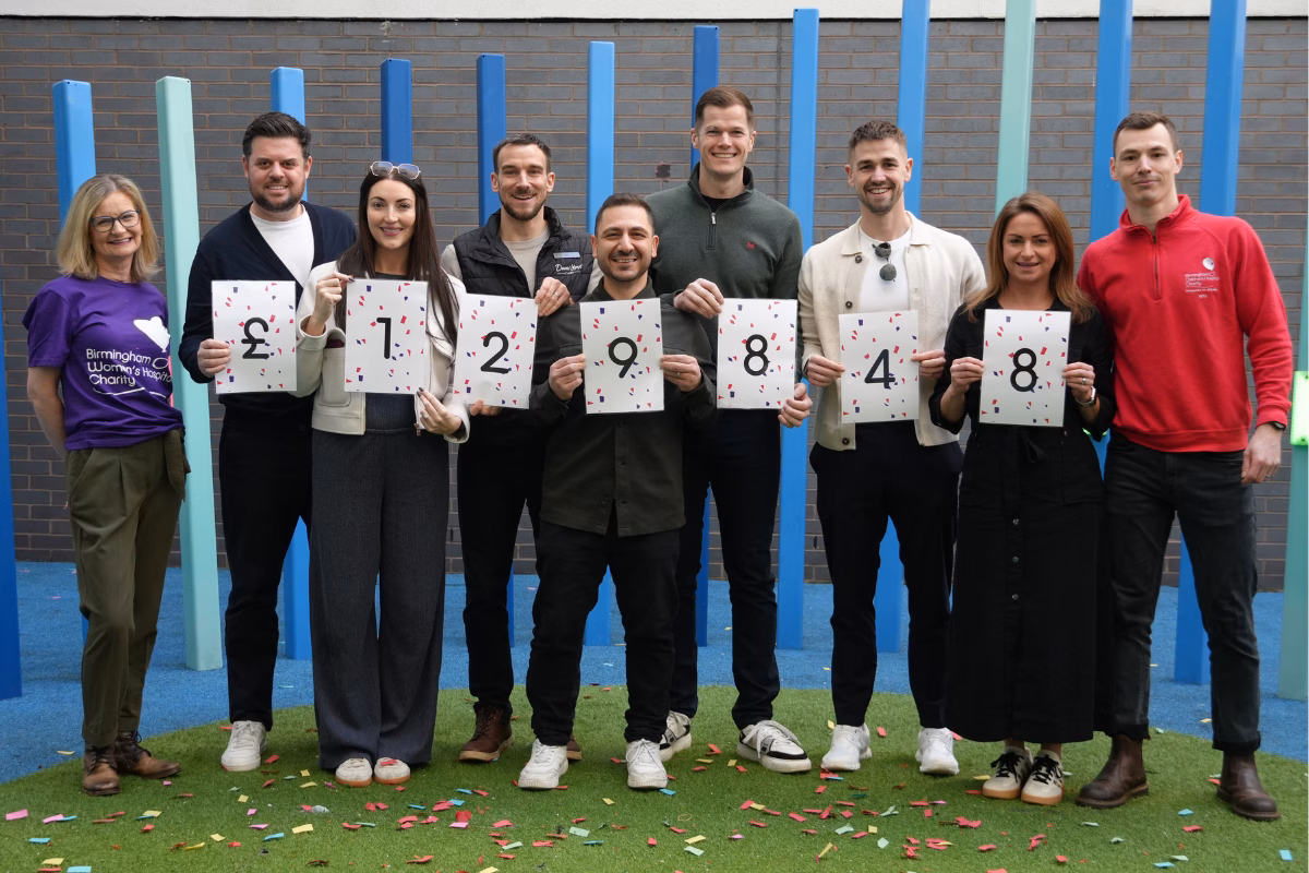 David Lloyd staff holding cards with fundraising total £129,848
