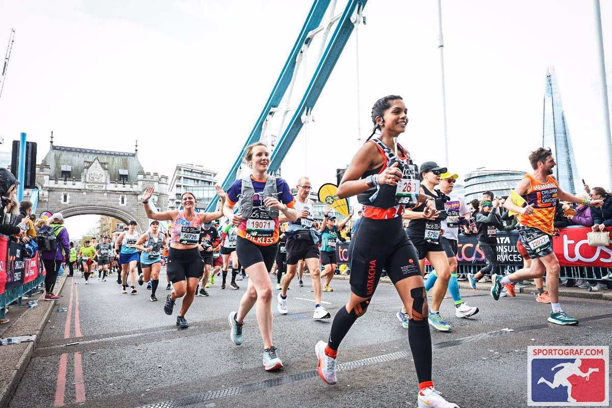 Woman running in crowd over bridge at London Marathon