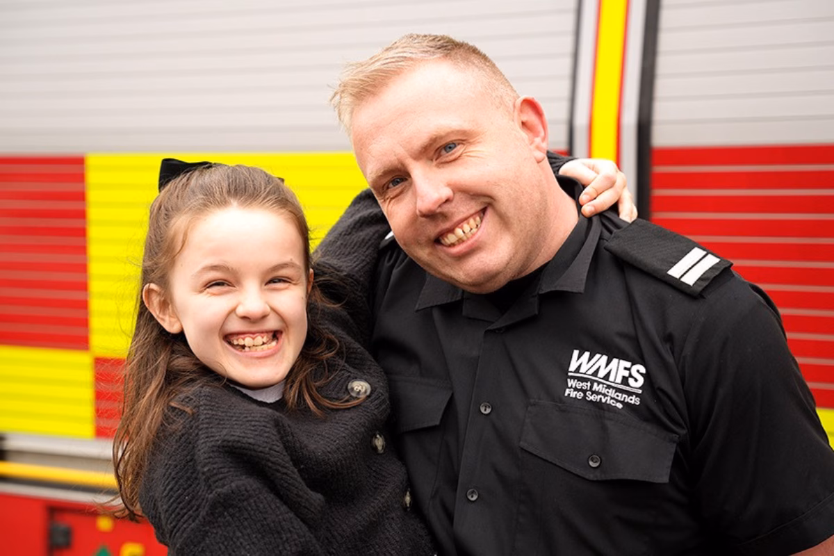 Smiling Evie (left) with her dad Simon Mahon (right) in front of fire engine