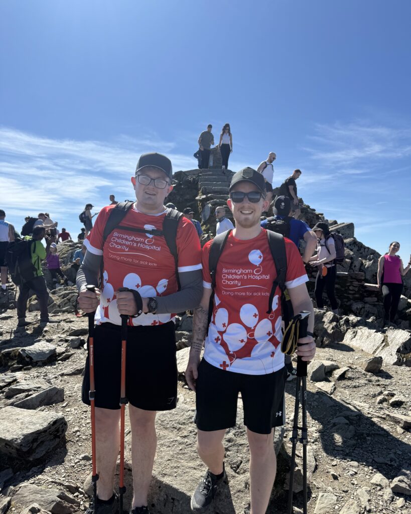 Callum and Josh standing in front of mountain peak