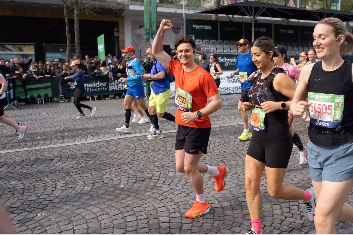 Stevie Hayward waving and running the Paris Marathon