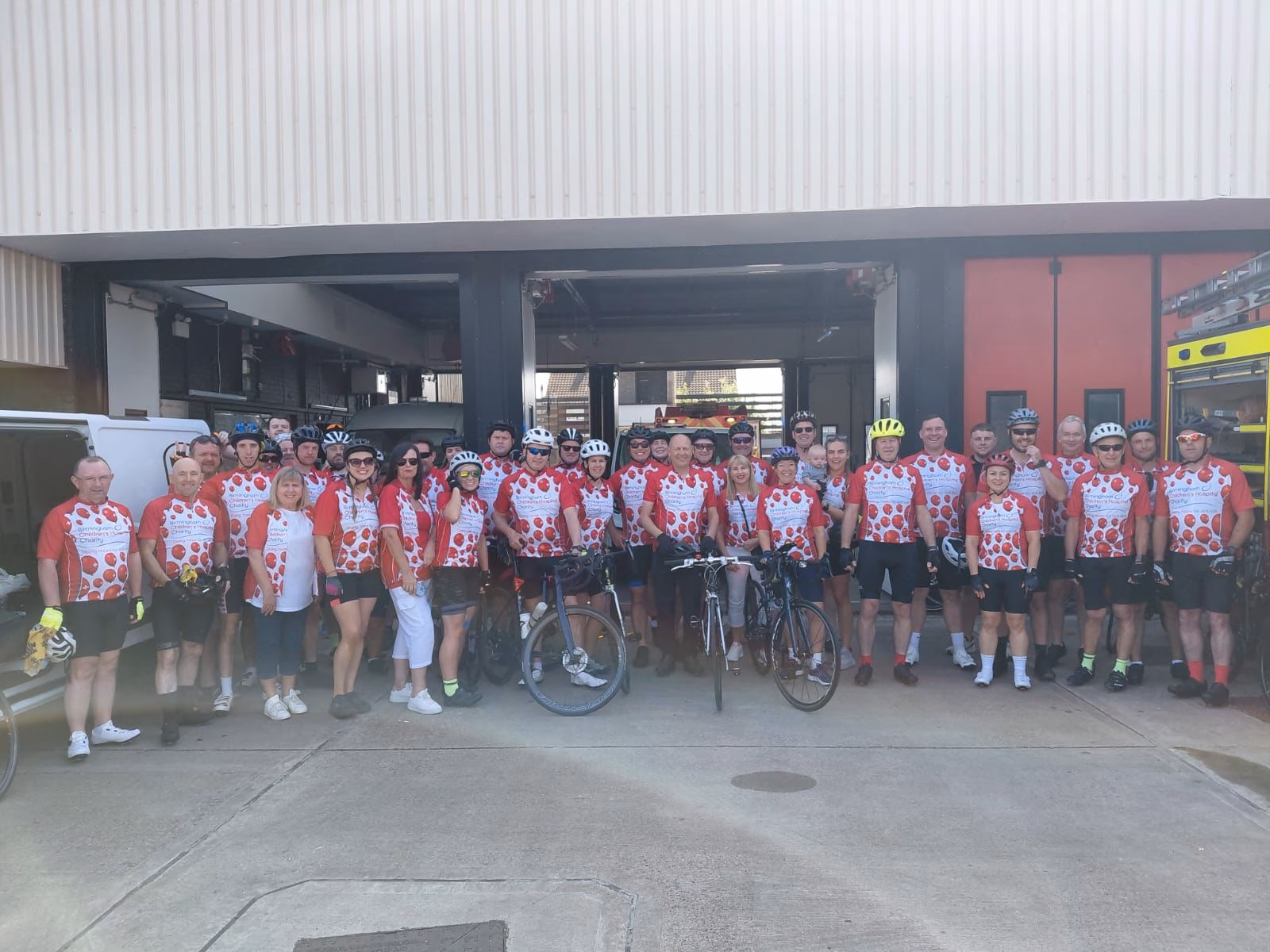 Line of cyclists in red charity gear
