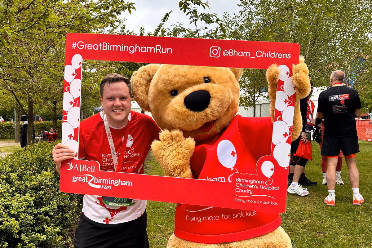 Smiling man with Bertie Bear in red photo frame
