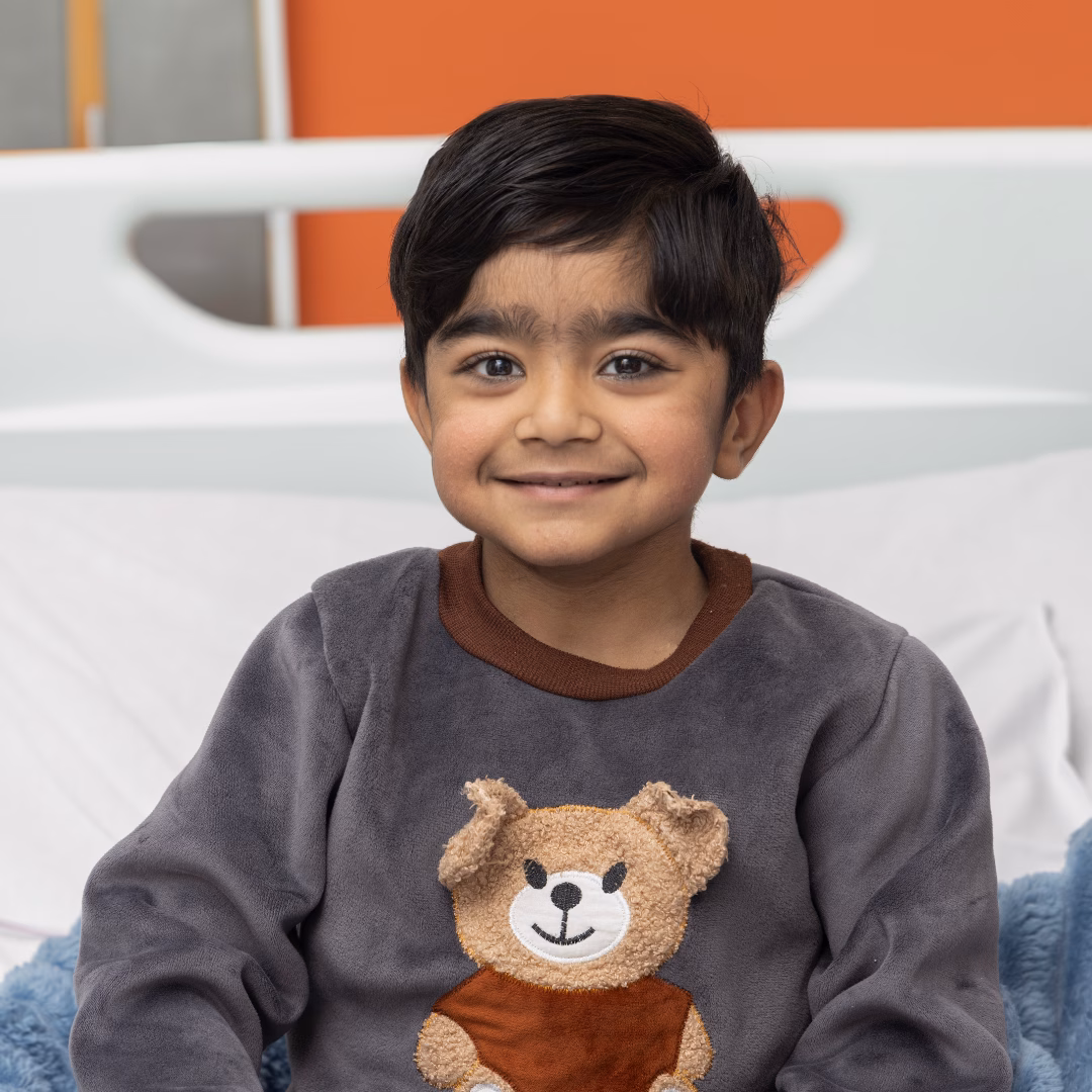 Young male patient, smiling and sitting up in the hospital bed