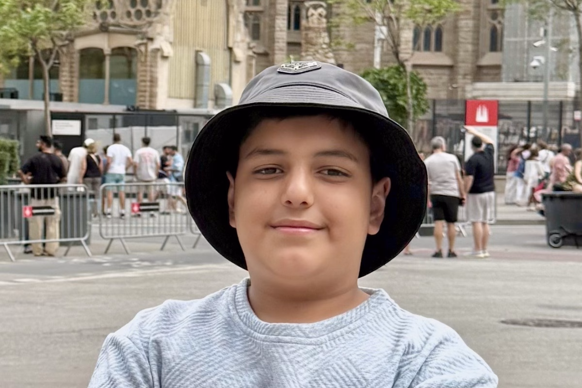 Boy in city street wearing sun hat