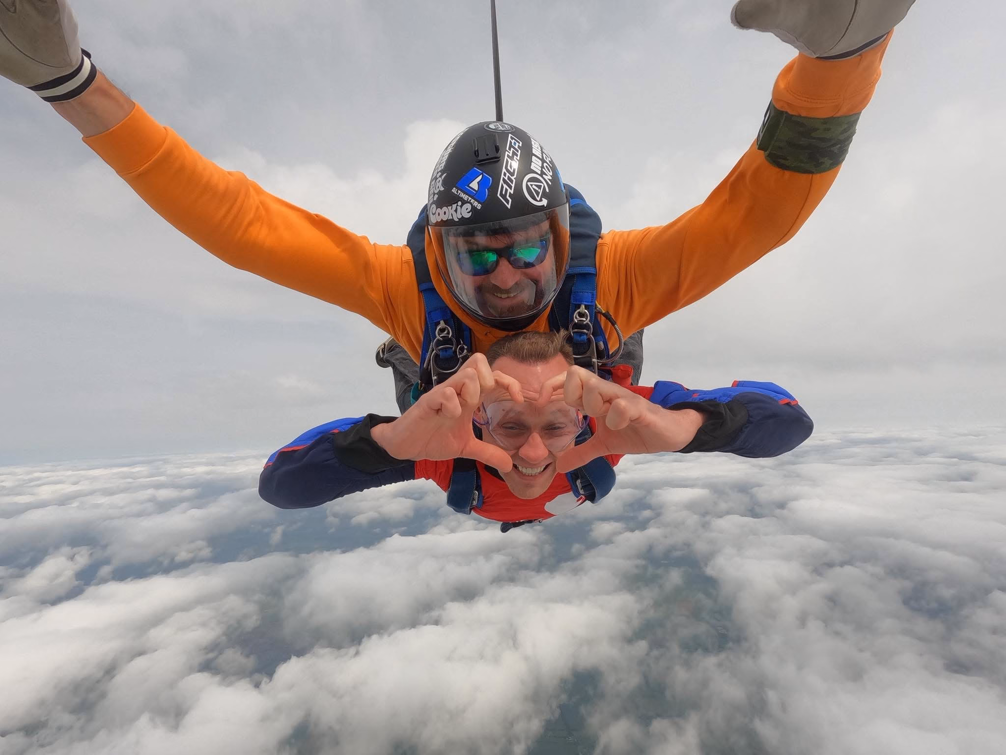 Man making heart shape with hands during skydive