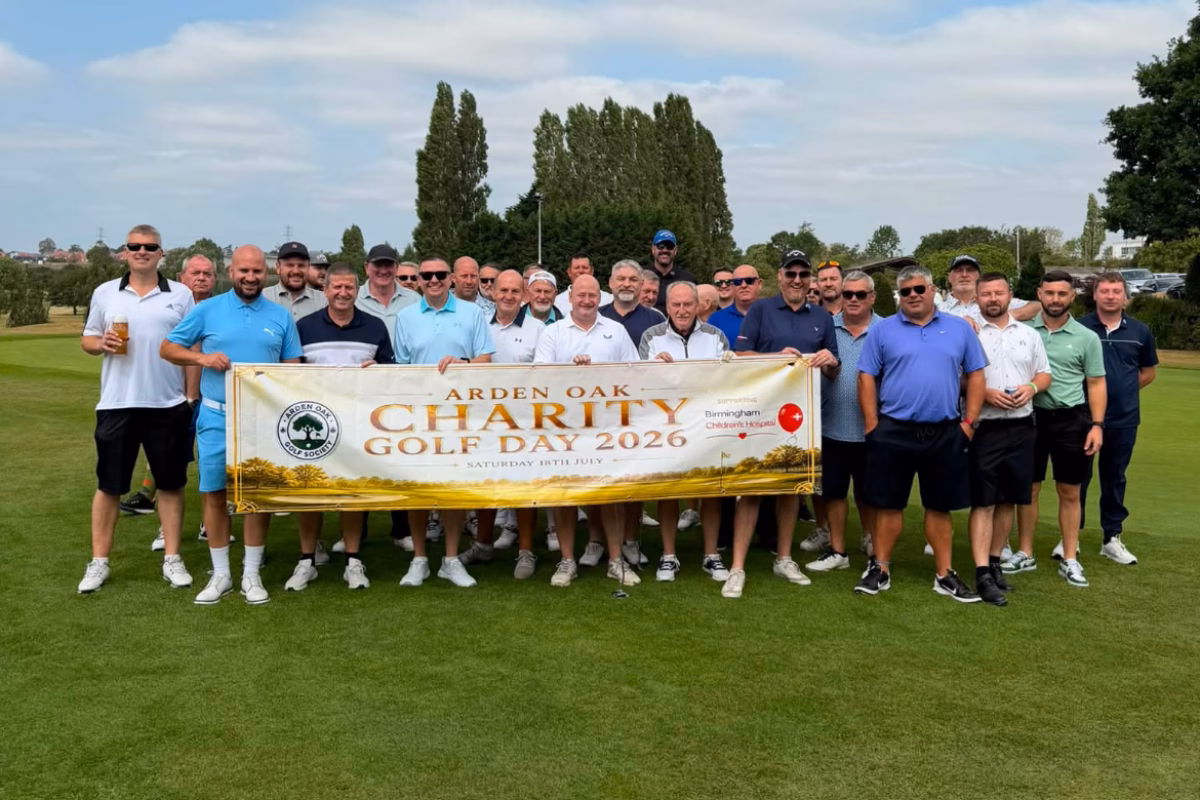 Group of Arden Oak Golf Society members holding banner on golf course