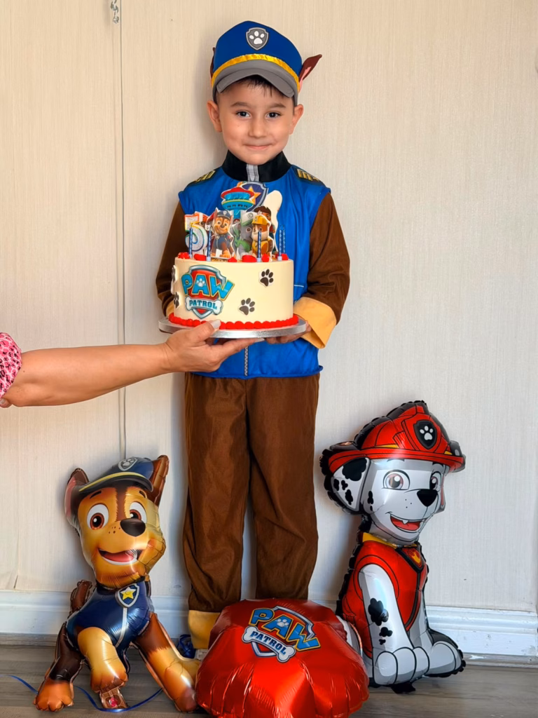 David holding paw patrol themed 5th birthday cake