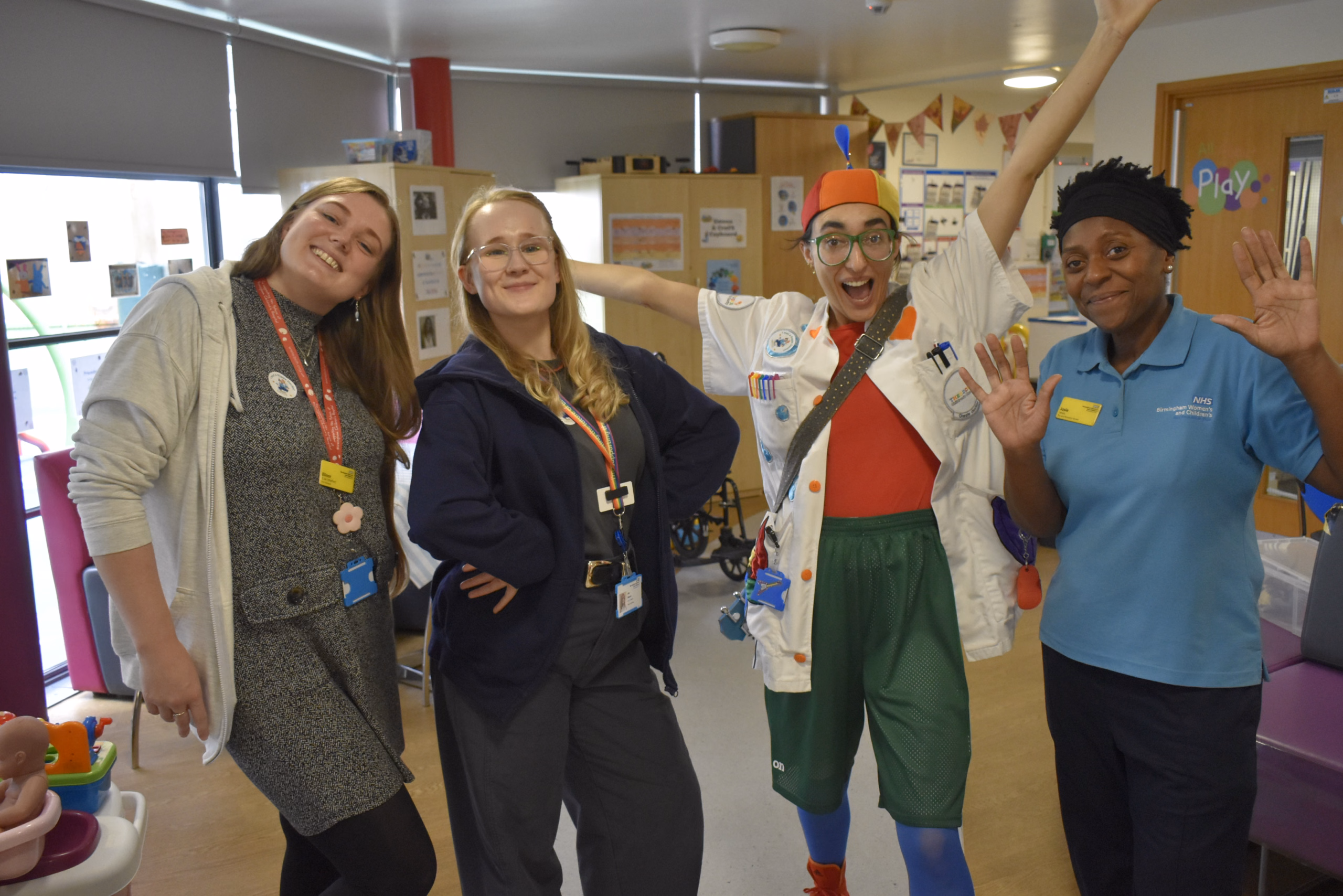 Four people smiling, one in clown outfit