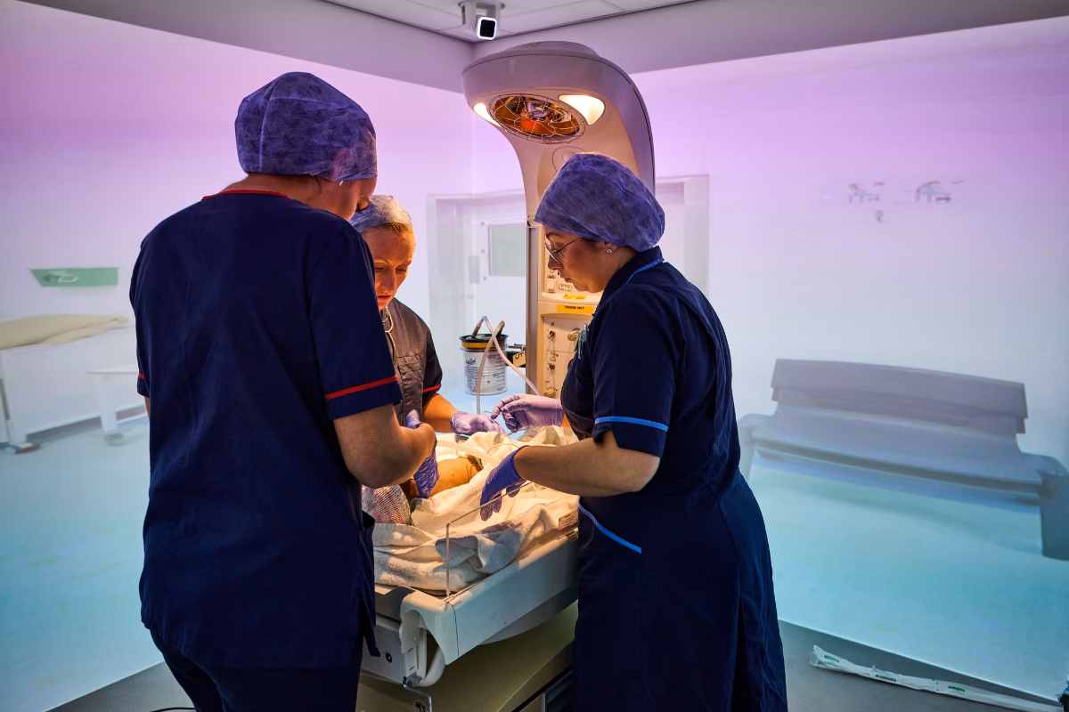 Clinicians in surgical gear simulating infant care after birth