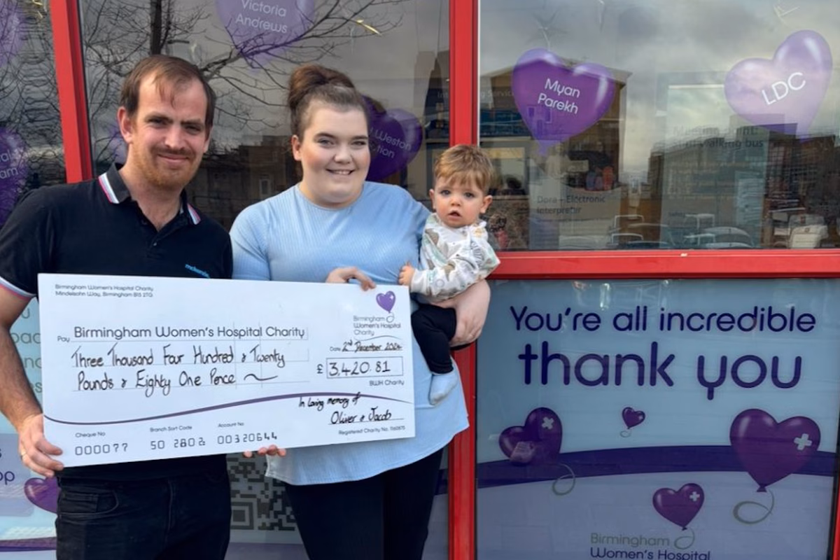 Georgina Agger-Haynes and her partner, Matt Clayton holding fundraising cheque outside women's hospital